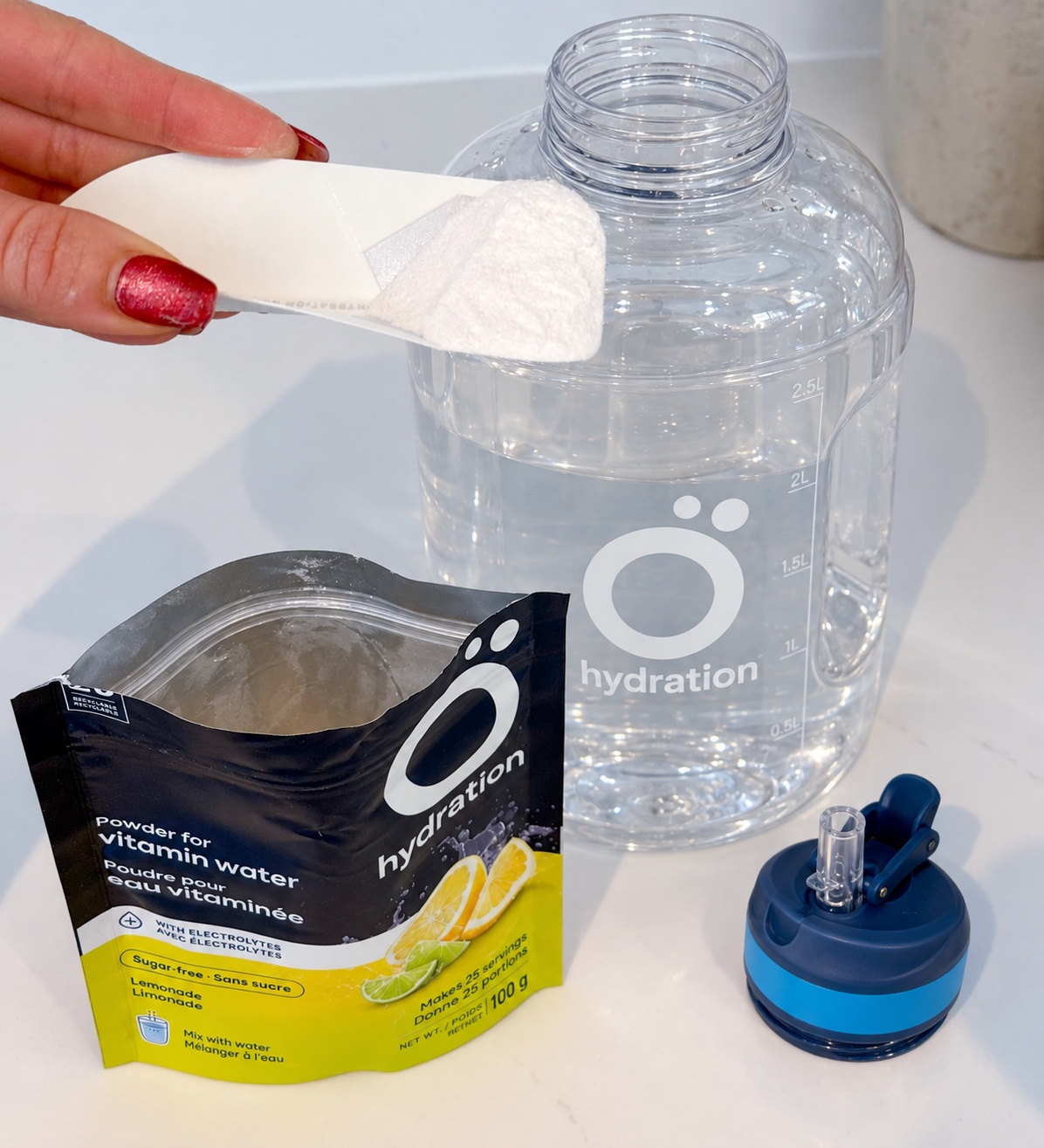 A scoop of Ö powder beside an open bag and the large 2.5 L bottle